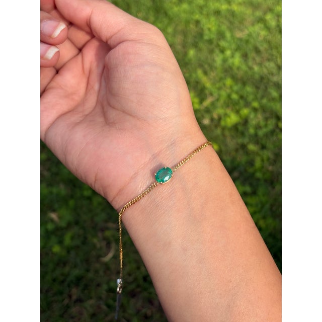 This elegant 1.53 carat oval-cut emerald chain bracelet is crafted in 14K yellow gold and features a vibrant natural...