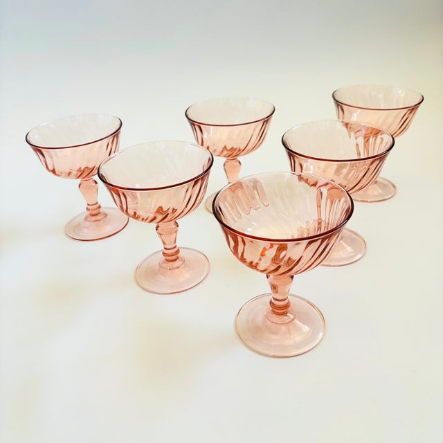 A set of 6 vintage coupe glasses in a pale blush pink hue. Each glass has a lovely swirl design. Made in France by...