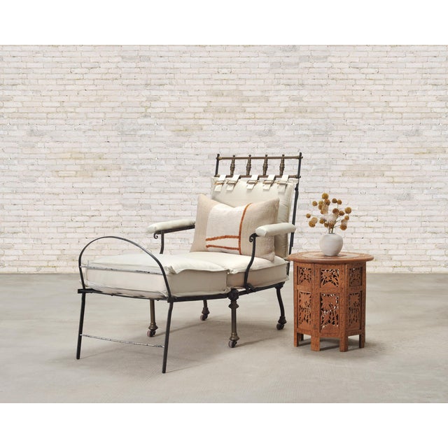 A spectacular late 19th/early 20th century French iron and bronze chaise longue or lounge, crafted in the Campaign style....