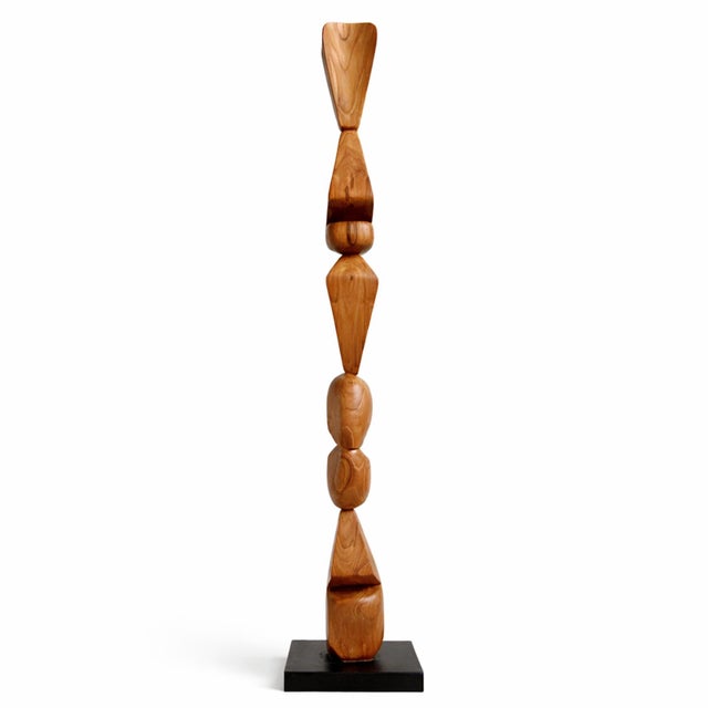 Modern teak sculpture on black iron stand. Warm honey teak with beautiful wood grain. Stacked shapes with narrow tall form...