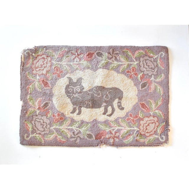 An antique, early 20th-century hooked wool textile featuring a cat in the center, with a floral and foliate botanical...