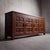Sculpted with bold dimensional woodwork, this four-door sideboard captures the austere weight and warmth of 1970s French...
