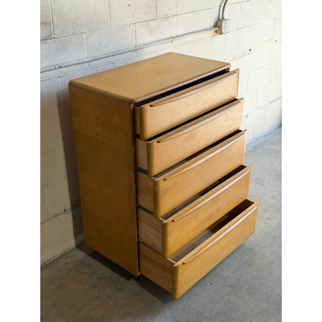 This vintage tallboy dresser features a clean architectural silhouette with five stacked drawers and integrated curved...