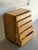 This vintage tallboy dresser features a clean architectural silhouette with five stacked drawers and integrated curved...