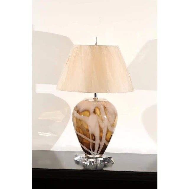 A striking pair of vintage hand-blown glass table lamps featuring sculptural vessel-form bodies in a warm caramel and...