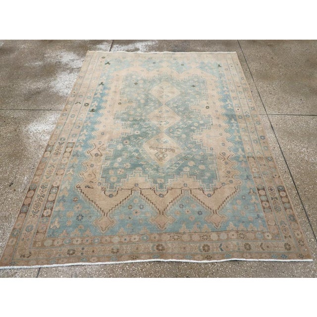 A vintage Persian Afshar accent rug. A pole medallion of three conjoint hooked straw diamonds centers the light blue-grey...