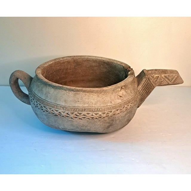 Large vintage hand-carved solid wood vessel with a rounded open body, long spout, loop handle, and beautifully incised...