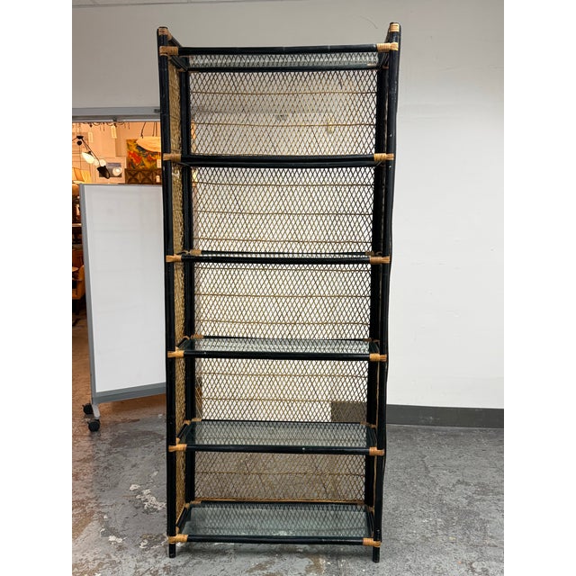 Design Plus Gallery presents a Mid 20th Century Black Bamboo Étagère with Wicker + Glass. The étagère takes on organic...