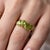 This stunning statement ring showcases a beautiful row of four graduated, pear-cut natural peridot gemstones. Each 6 x 4mm...