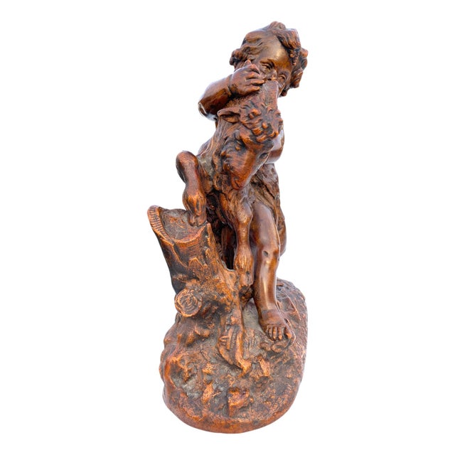 Charming mid-century French sculptural piece depicting a classical putto figure playfully grappling with a goat. This...