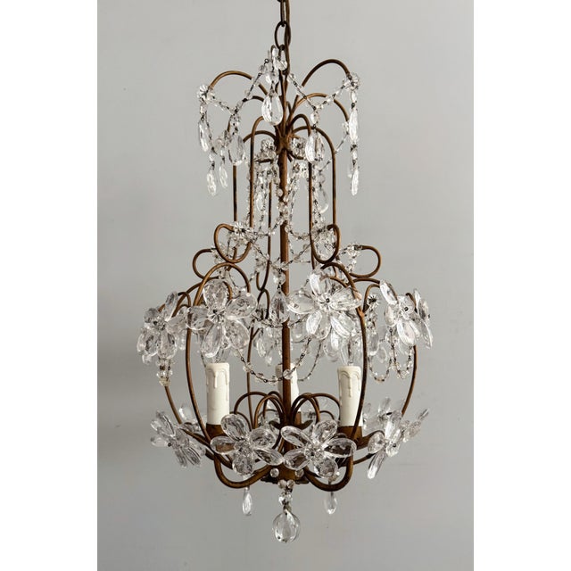 Gorgeous, 1960s Italian crystal beaded chandelier. The chandelier consists of a scrolled gilded-iron frame decorated with...