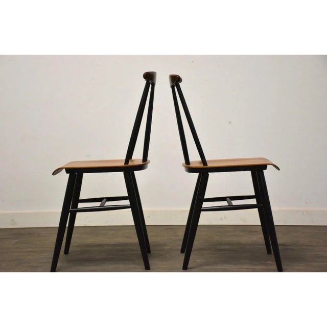 A pair of mid century modern teak dining chairs. Unmarked. Possibly by Ilmari Tapiovaara. Seat height is 17.5”. 16.75”...