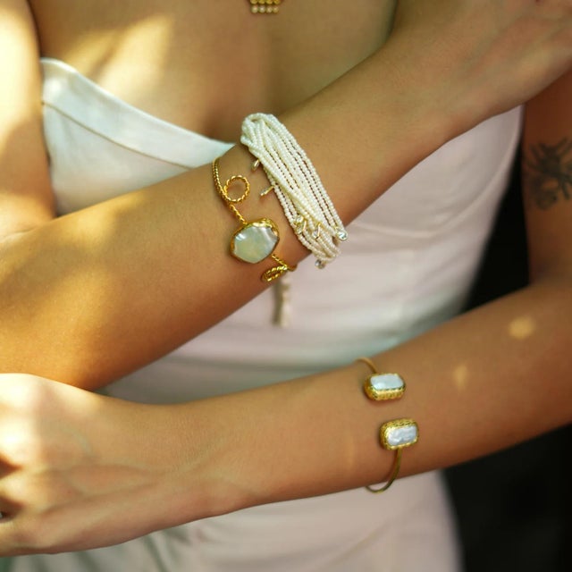 Unveil the allure of ancient royalty with the Pearl Stone Gold Twisted Cleopatra Cuff Bracelet. This exquisite piece is...