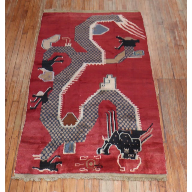 A 3rd quarter of the 20th-century Chinese rug with a dragon motif on a dark red field