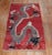 A 3rd quarter of the 20th-century Chinese rug with a dragon motif on a dark red field