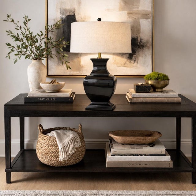 A striking sculptural black ceramic table lamp with a high-gloss finish and clean-lined 14” linen drum shade. Compact in...