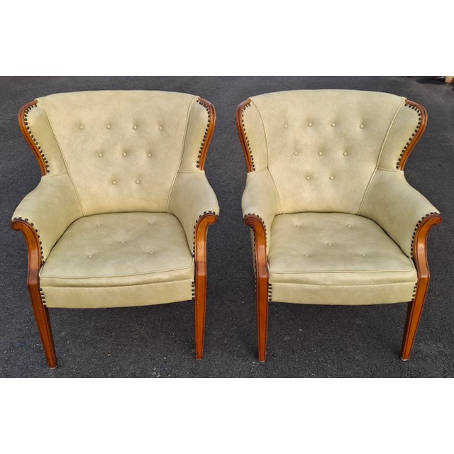 A Pair of Mid 20th Century Mahogany and Tufted Vinyl Upholstered with nail trims low Wingback Chairs. Measures: 29.5" in...