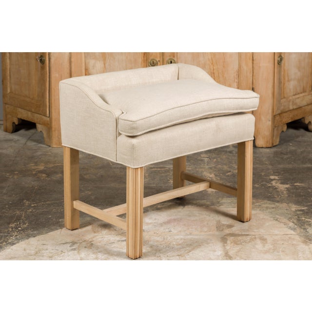 An English stool from circa 1920 with slightly raised back, straight carved legs, H-Form cross stretcher and newly...