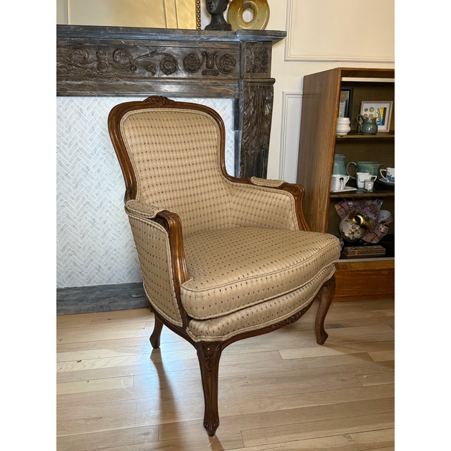 A charming vintage French Louis XV–style armchair featuring a beautifully carved wood frame with floral detailing,...
