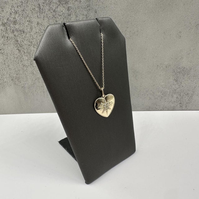 This charming diamond heart necklace in 10kt yellow gold features 0.07 carats total weight of natural HI SI2–I1 round...