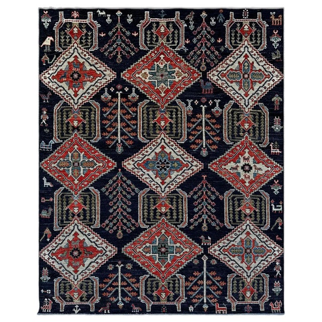 A striking navy tribal rug in the Qashqai manner, with three columns of latch-edged diamond medallions in brick red and...