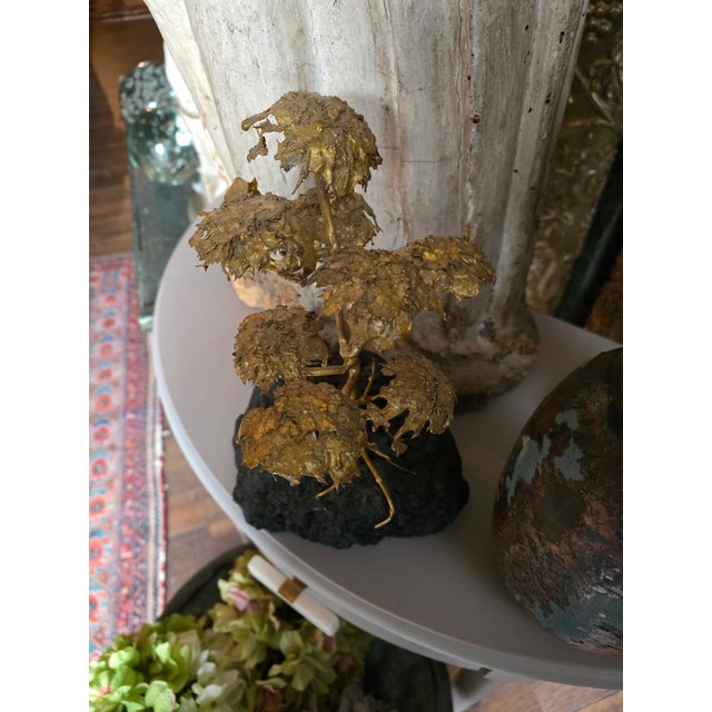 Great looking gilt metal brutalist style mid Century tree sculpture on a black lava type stone base.