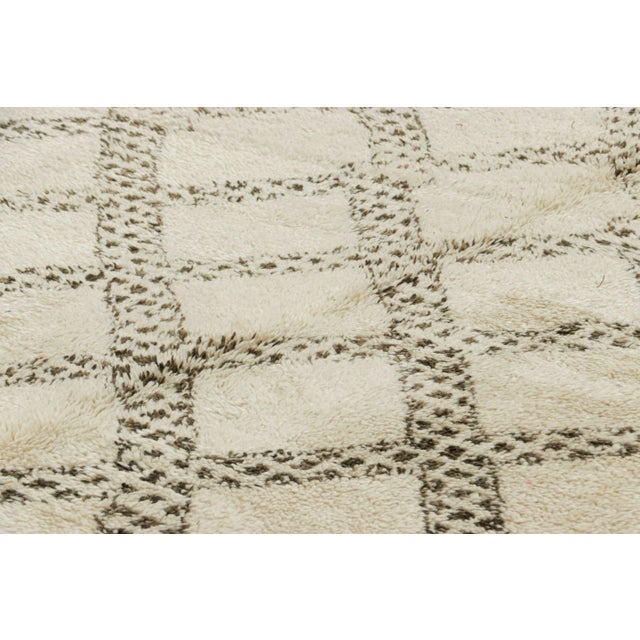 Hand-knotted in wool and originating from Morocco circa 1950-1960, this 7x13 vintage rug is a rare and among the most...