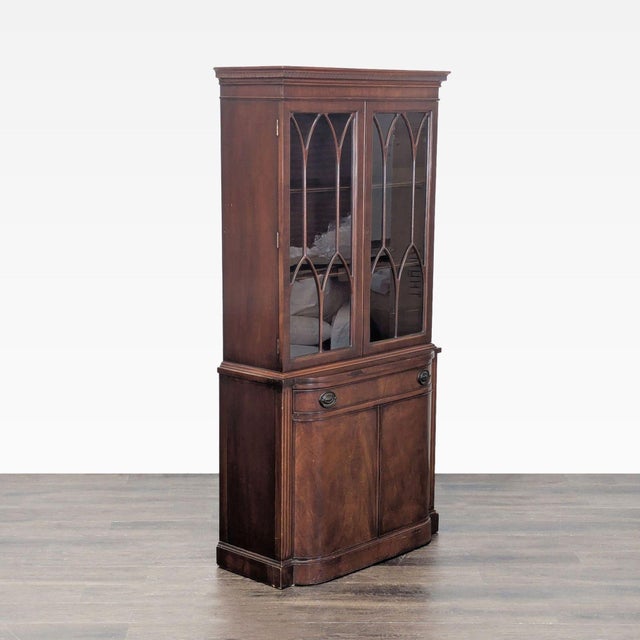 This classic Drexel hutch features elegant glass doors with a wood frame, three upper shelves for display, and a spacious...