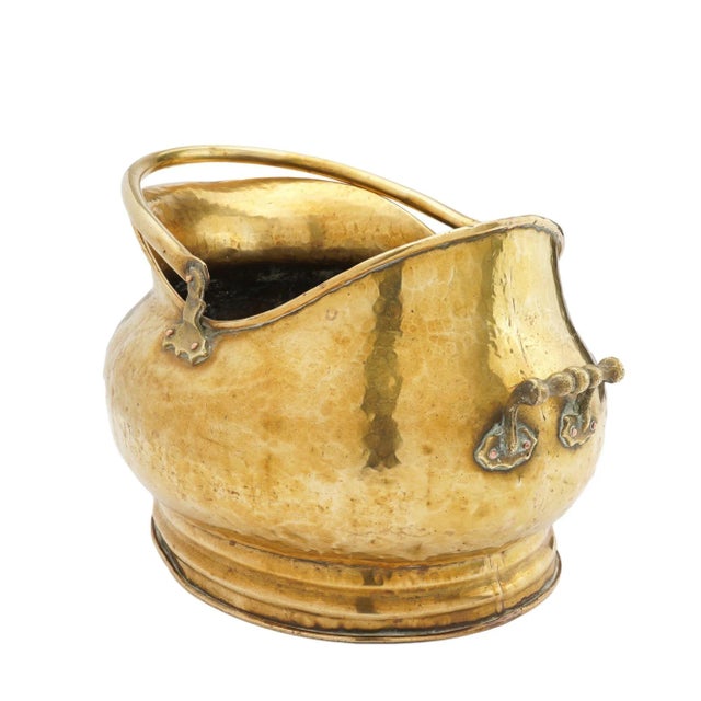 Generously proportioned brass bombe (helmet form) coal hod on a circular footed base. Hand hammered brass with cast brass...