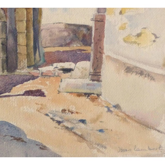 Charming watercolor landscape painting of an arched stone entrance to a small village in Provence, France by artist Jean...