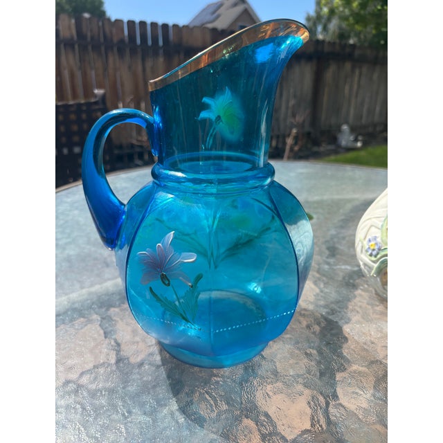 Lovely handblown hand painted Fenton Lemonade Pitcher circa 1915. The glass has a panel optic design in a peacock blue...