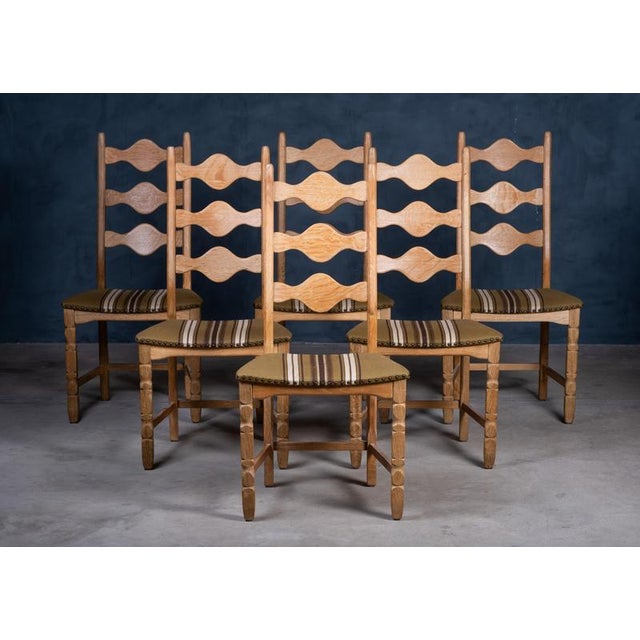 Elegant set of six solid oak dining chairs designed by Henning Kjærnulf and produced by Nyrup Møbelfabrik in the 1960s....