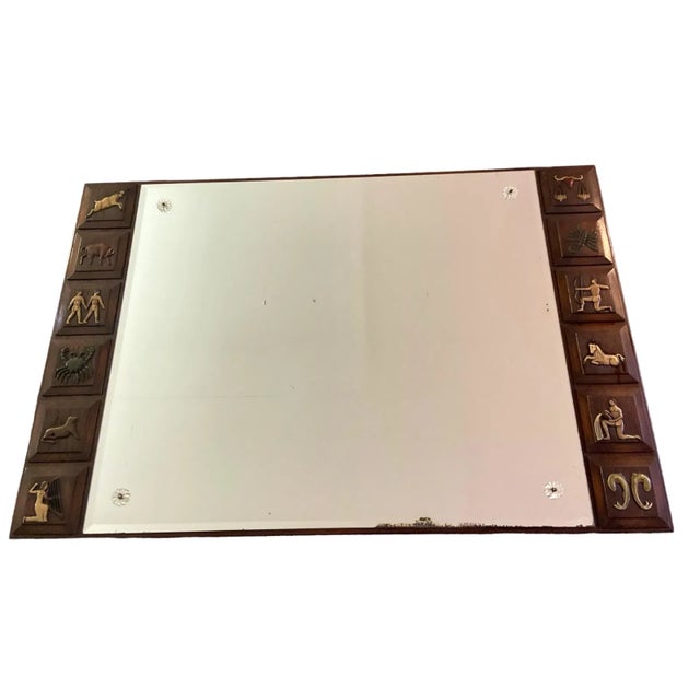 47" H x 31" W x .5" D Unusual Mid Century Zodiac mirror. Each sign is carved into the wood frame. Rosette Detailing on the...