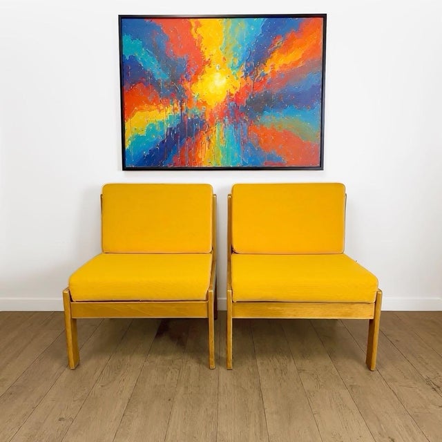 Here is a superb pair of vintage armchairs in solid pine and vibrant yellow fabric, with a design that is both minimalist...