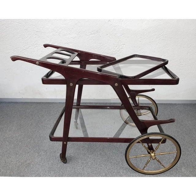 Fantastic Mid-Century wood bar cart with glass serving trays. This piece is attributed to Cesare Lacca and it was designed...