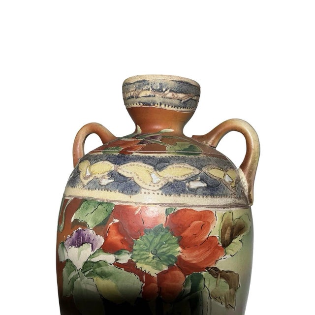 A quietly sculptural antique Japanese art pottery vase with a balanced double-handled silhouette and hand-painted floral...