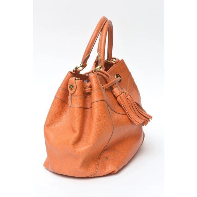 This fabulous top handled vintage original MCM Company orange pebbled leather and gold plated embellished hand bag has 2...