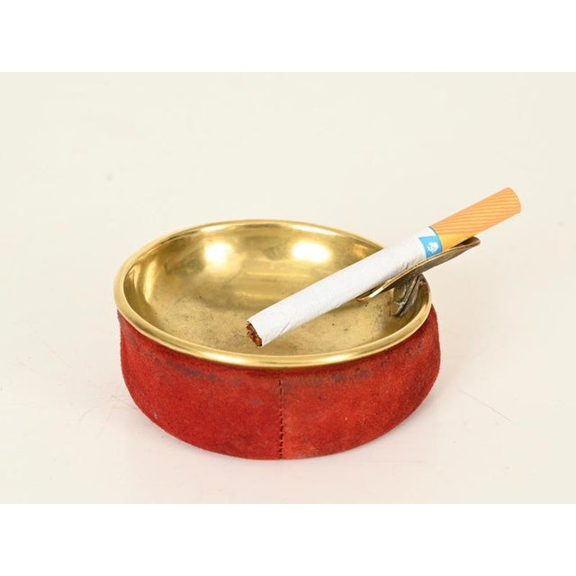 Wonderful and unique Mid-Century Italian ashtray in solid brass and deep red-colored suede. This stylish piece was...