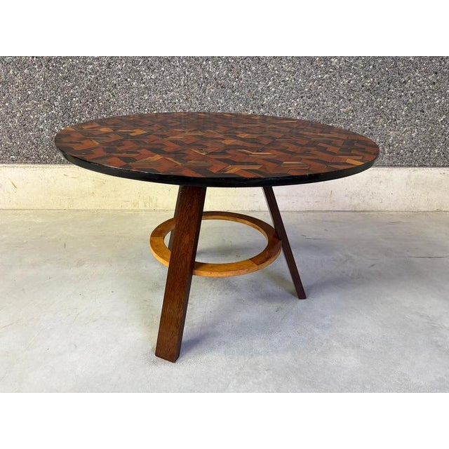 Elegant art deco center table or dining table with marquetry inlay top and a tripod base. The beautiful mix of colours and...