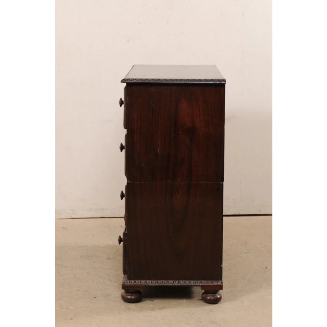 A British Colonial rosewood chest of drawers from the early 20th century. This antique chest from India is made of...