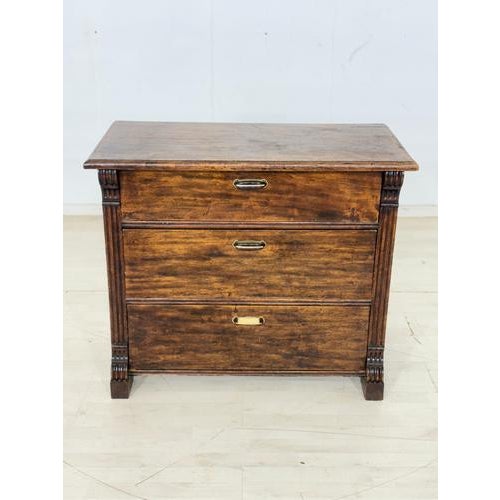 Vintage chest of drawers in colonial style, featuring classic English design. The decorative brass handles lend the piece...