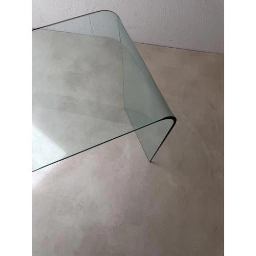 Minimalist Italian design from the 1980s, crafted from heavy curved clear glass. The table is made from a single...
