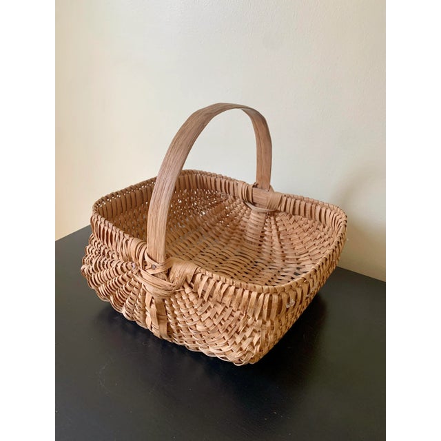 A beautifully woven early 20th century American splint oak basket with warm honeyed tones and a tightly constructed...