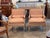 A pair of carved and giltwood bergere armchairs upholstered in a rose and cream striped fabric, with loose seat and back...