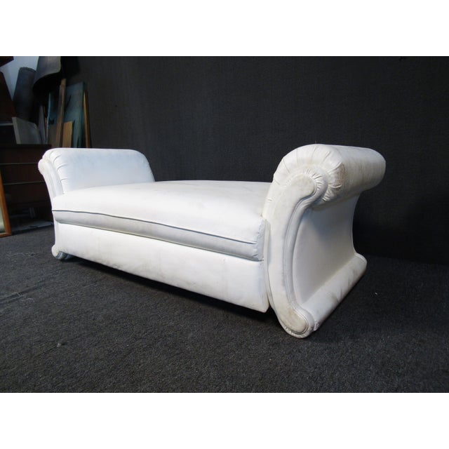 This large and unique white loveseat features curving arms and white vinyl upholstery.