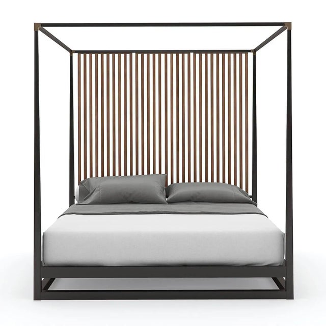 A Mid Century Modern style canopy bed with a dramatic vertical slat back design. It has an architecturally inspired design...