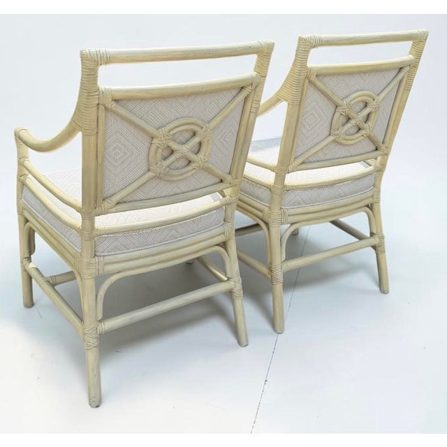 A distinctive pair of vintage rattan armchairs featuring sculptural target-style backs, intricately wrapped frame details,...