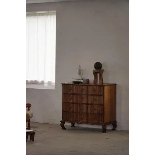 An elegant baroque chest of drawers in solid oak, crafted in the 18th century. The piece features a beautifully curved and...
