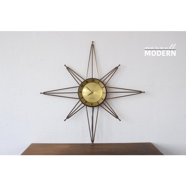 Gorgeous vintage MCM electric starburst wall clock by Lux from the 1950s. Alternating brass spokes radiate from a gold-...