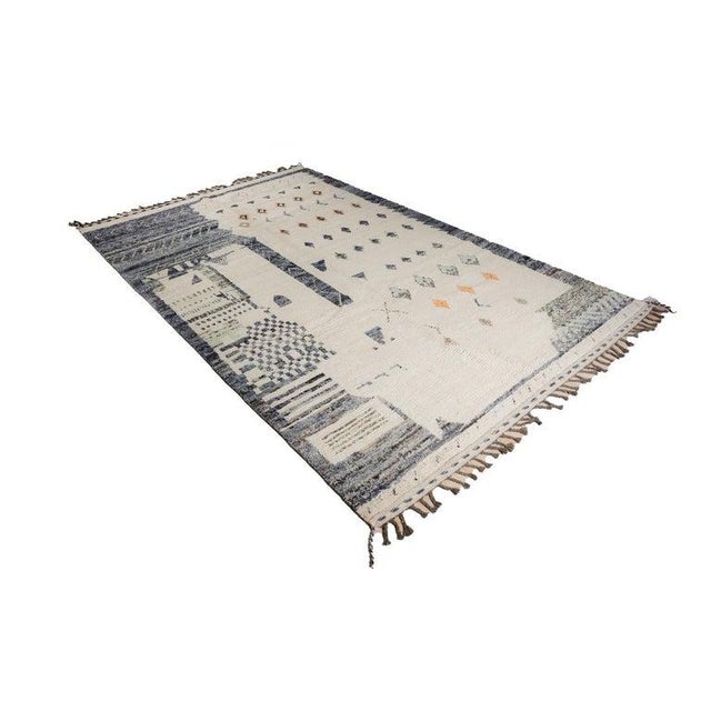 This hand knotted pile rug features a primary gray color and is crafted from natural wool. Modeled after the traditional...